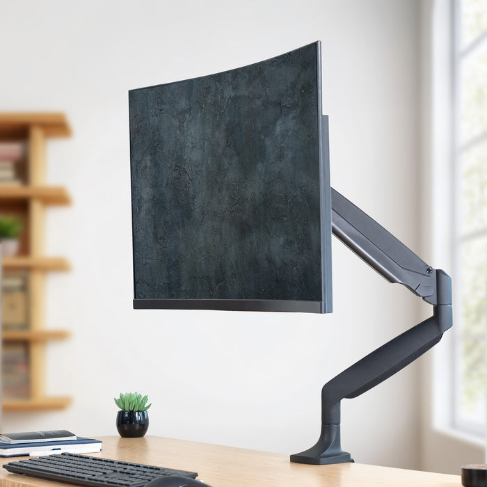 Pneumatic Arm Adjustable Single Monitor Desk Mount on desk in bright room.