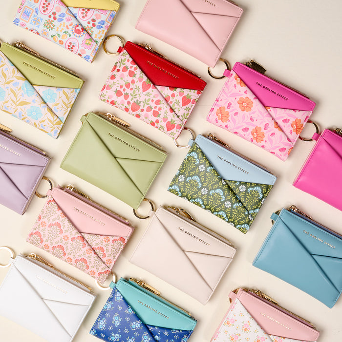 The Darling Effect’s Poppin' Petals Hot Pink Luxe Pocket Wallet features vibrant vegan leather, a gold zipper, and key ring. This compact pastel wallet is perfect for everyday style—a chic essential in bold hot pink with a unique floral design.
