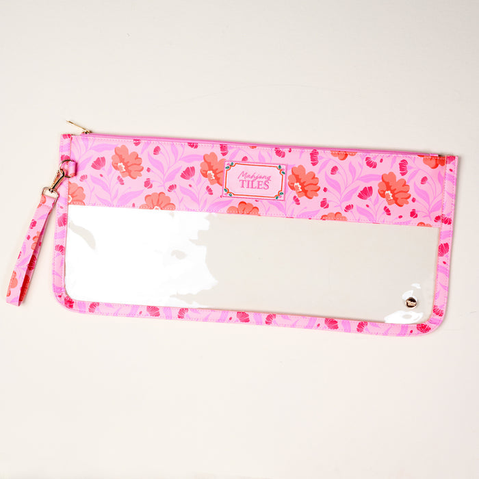 The Darling Effect's Poppin' Petals Hot Pink Mahjong Tile Keeper Pouch features a pink floral pattern, clear front panel, and wrist strap—ideal for organizing your Mahjong essentials in style. "Marilyns TILES" label at top center. Displayed on light surface.
