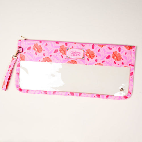 The Darling Effect's Poppin' Petals Hot Pink Mahjong Tile Keeper Pouch features a pink floral pattern, clear front panel, and wrist strap—ideal for organizing your Mahjong essentials in style. "Marilyns TILES" label at top center. Displayed on light surface.
