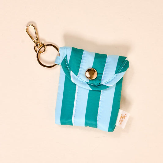 The Darling Effect Sicily Stripes Teal Puffy Earbud Case is a small, square, light blue and teal striped pouch with a gold keyring and clasp, snap closure, and white side tag—ideal for holding your wireless earbuds.