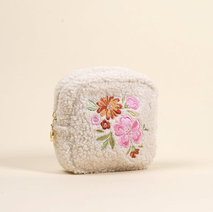 The Square Dainty Floral Pink Teddy Pouch by the-darling-effect is a plush cream sherpa pouch featuring embroidered pink, orange, and red flowers with green leaves.