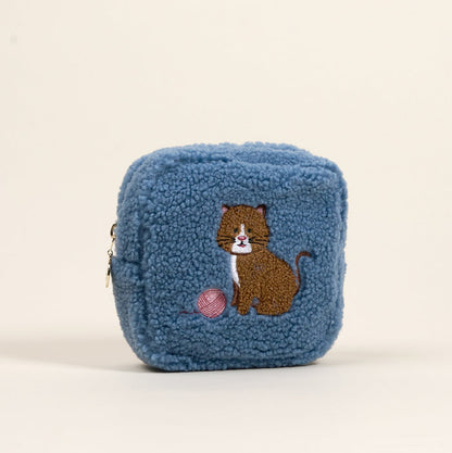 The Darling Effect's Square Kitty Corner Teddy Pouch features blue sherpa with an embroidered brown cat and yarn—an adorable, playful addition to your accessories.