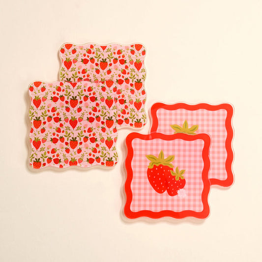 Brighten your table with The Darling Effect’s Strawberry Fields Table Talk Acrylic Coaster Set: four scalloped-edge coasters—two in pink with all-over strawberries and two with a red gingham design featuring large strawberries at the center.