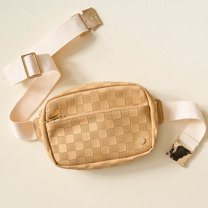 The Darling Effect’s Tan Urban Check Belt Bag is a trendy accessory with a beige checkerboard pattern, vegan leather accents, cream canvas strap, and gold hardware.