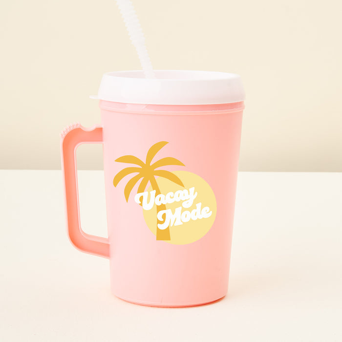 The Darling Effect Vacay Mode 34 oz Mega Mug is a pink plastic tumbler with handle, white lid, straw, and a yellow palm tree and sun design with “Vacay Mode” text. Great for events or daily use; background is plain light color.