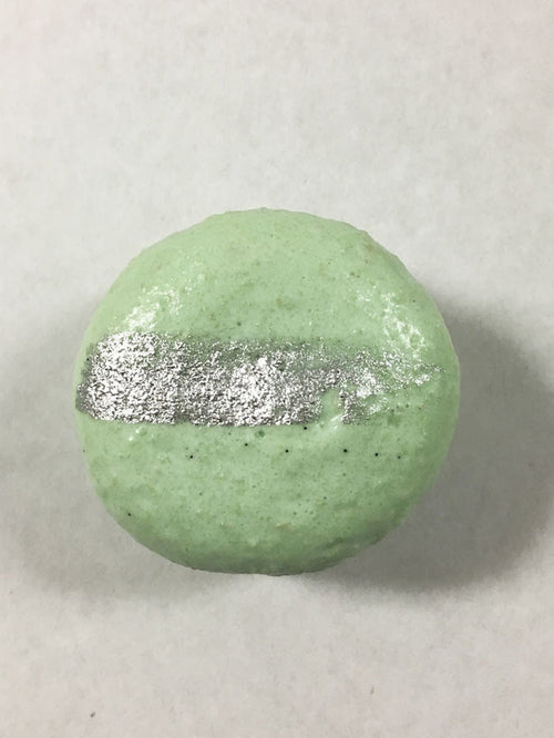 A green-colored macaron with a silver streak on its surface.