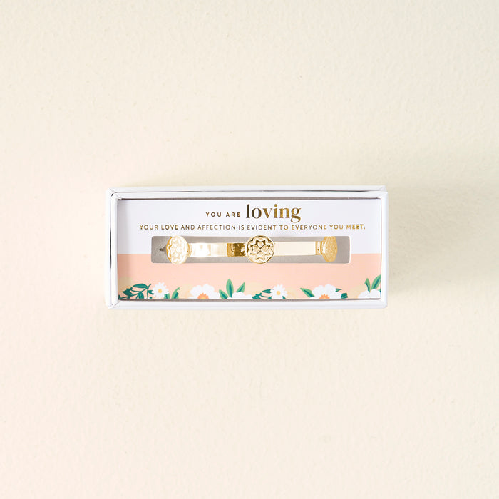 Gift-ready, The Darling Effect’s You Are Loving Skinny Stacker Bracelet is 14k gold plated with floral designs, packaged in a white box with peach and floral pattern that reads: YOU ARE loving YOUR LOVE AND AFFECTION IS EVIDENT TO EVERYONE YOU MEET.