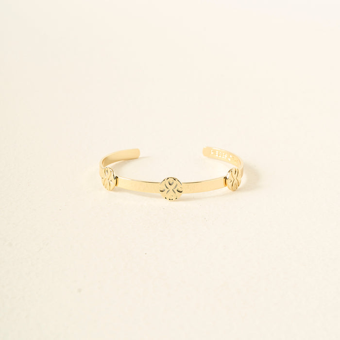 The Darling Effect's "You Are Loyal" Skinny Stacker Trait Bracelet is a 14k gold plated adjustable cuff, engraved with three floral designs, shown on a light cream background—a gift-ready and elegant accessory.