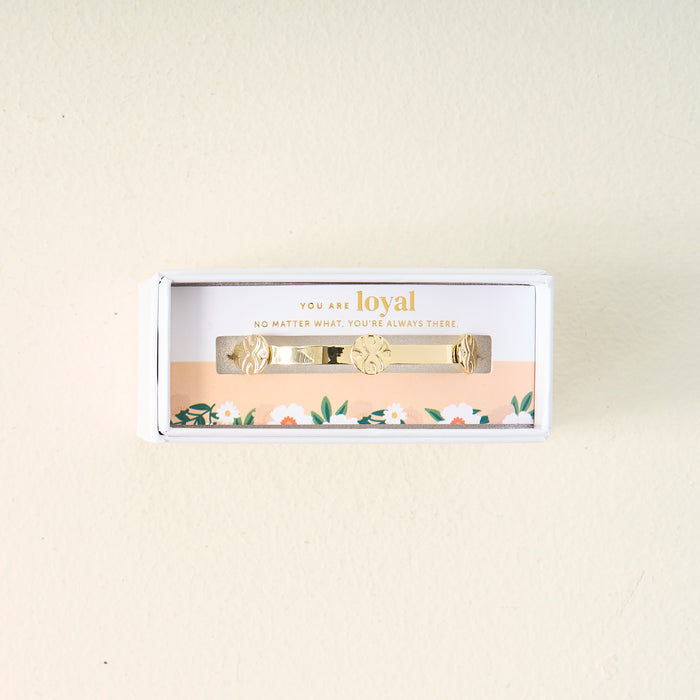 The Darling Effect's You Are Loyal Skinny Stacker Trait Bracelet comes in a gift-ready box with a floral border and the message: "You are loyal. No matter what, you're always there," displayed on a light, off-white surface.