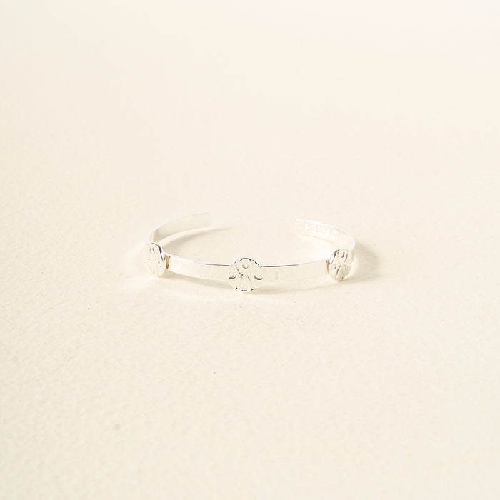 The Darling Effect’s You Are Loyal Skinny Stacker Trait Bracelet is a minimalist silver adjustable cuff with three evenly spaced motifs, shown on an off-white background—perfect as a gift-ready jewelry piece.